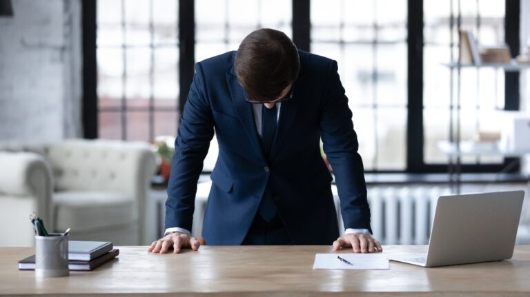 businessman stands at desk in office