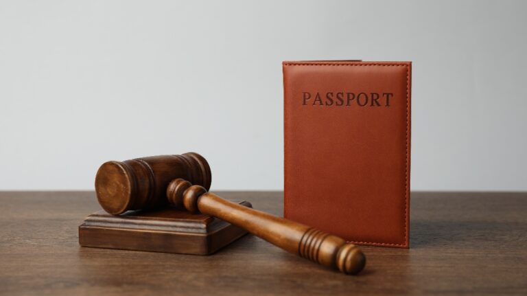 Passport and judge's gavel on a wooden table