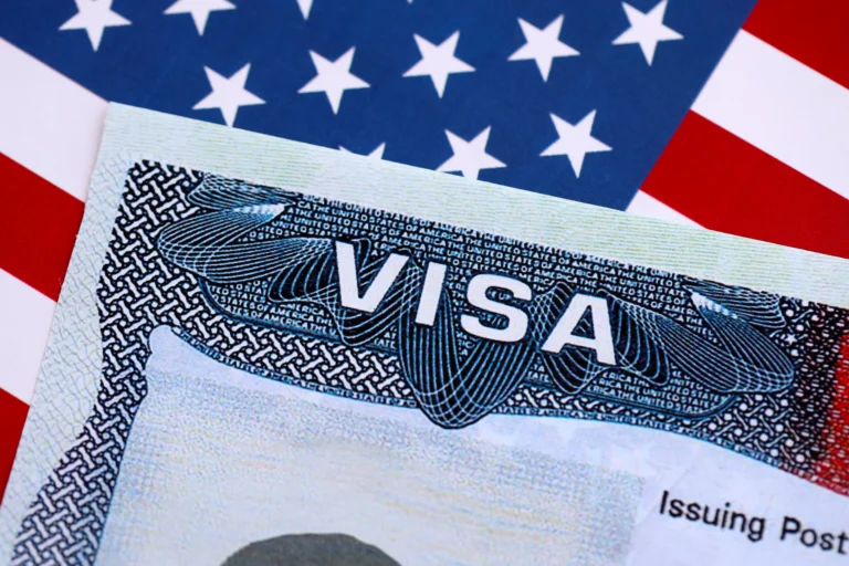 Close-up of a United States visa document on an American flag background.