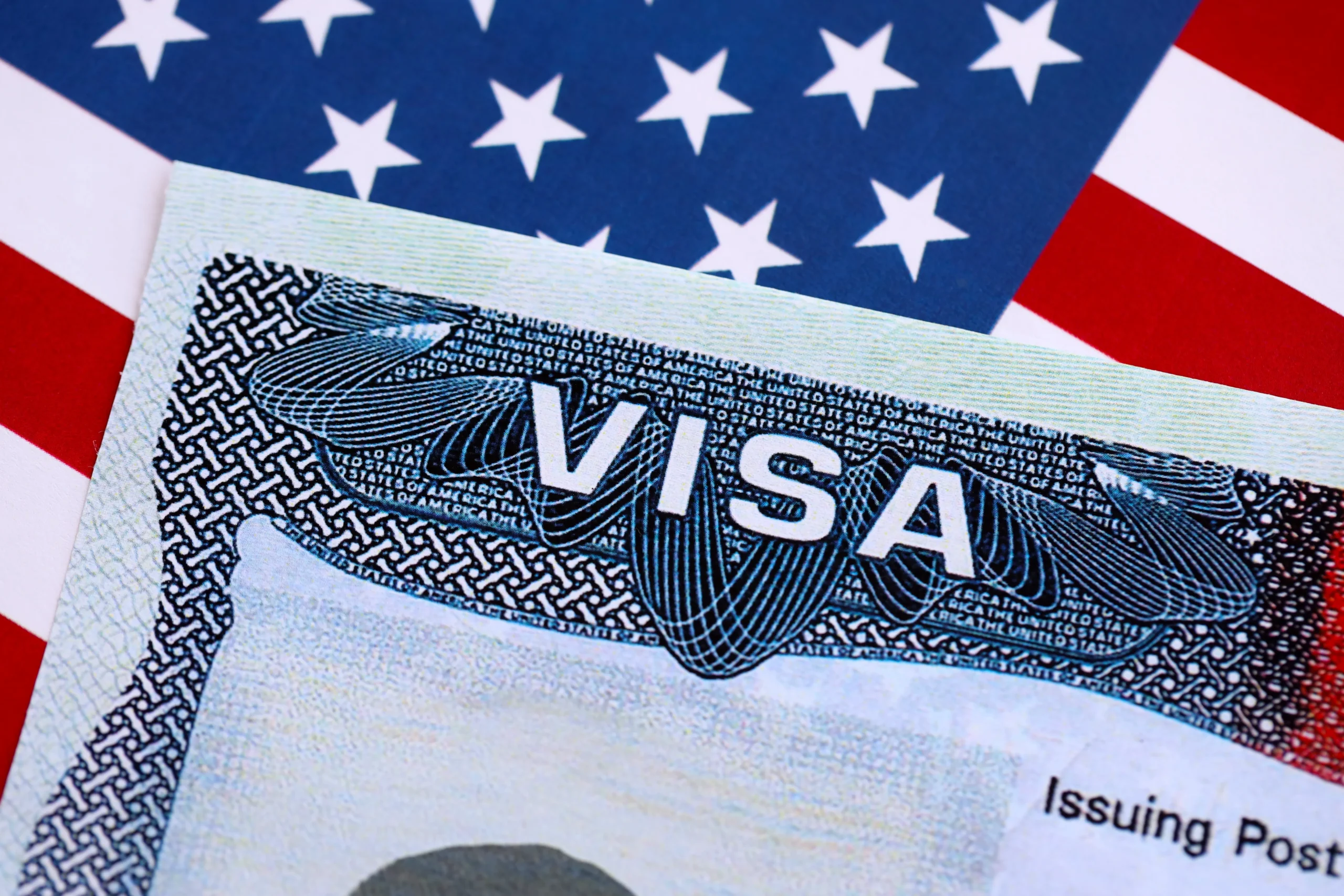 Close-up of a United States visa document on an American flag background.