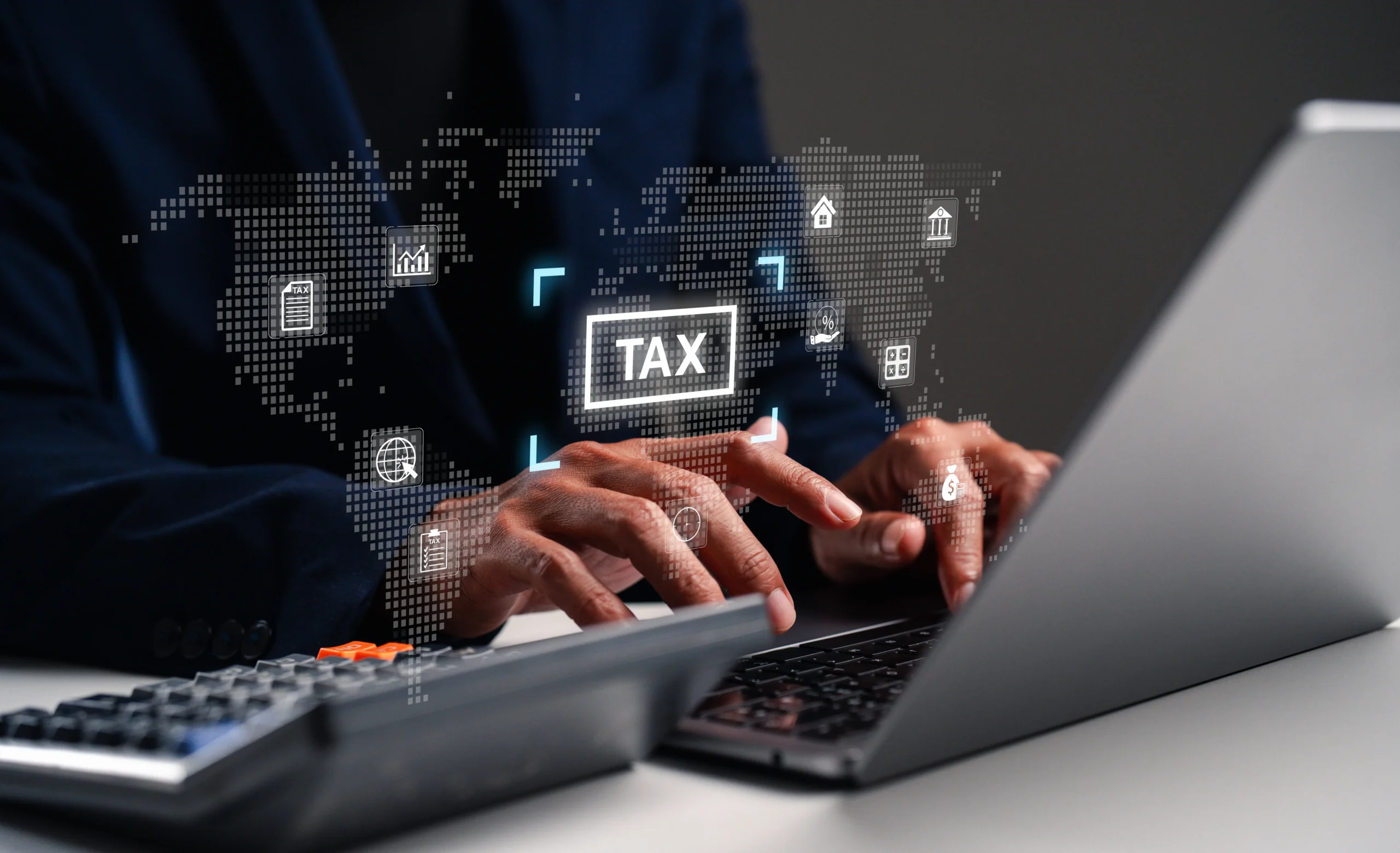 Person typing on laptop with digital tax-related icons and world map overlay.
