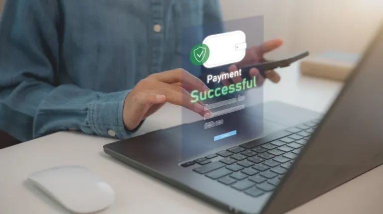 Person using laptop and smartphone with digital "Payment Successful" notification displayed.