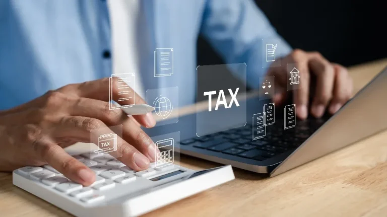 Person using calculator and laptop with floating tax-related icons and text.