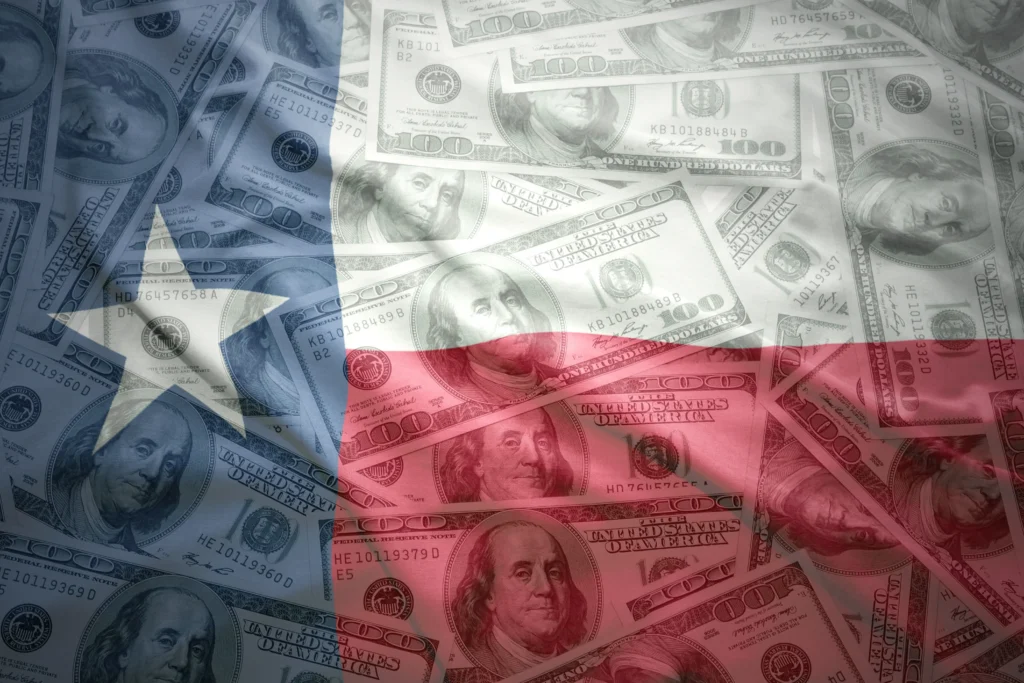 Overlay of the Texas state flag on multiple US one hundred dollar bills.