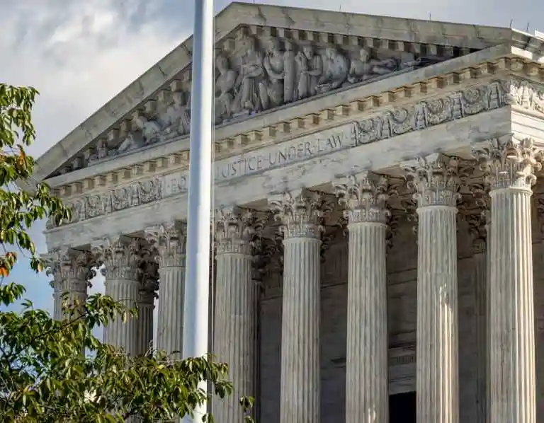 Exterior view of a classical courthouse facade with Corinthian columns and sculpted frieze.